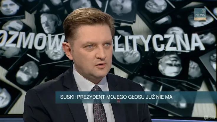 Mężczyzna w garniturze podczas programu „Rozmowa Polityczna” w studiu telewizyjnym, na pasku informacyjnym napis: „SUSKI: PREZYDENT MOJEGO GŁOSU JUŻ NIE MA”.