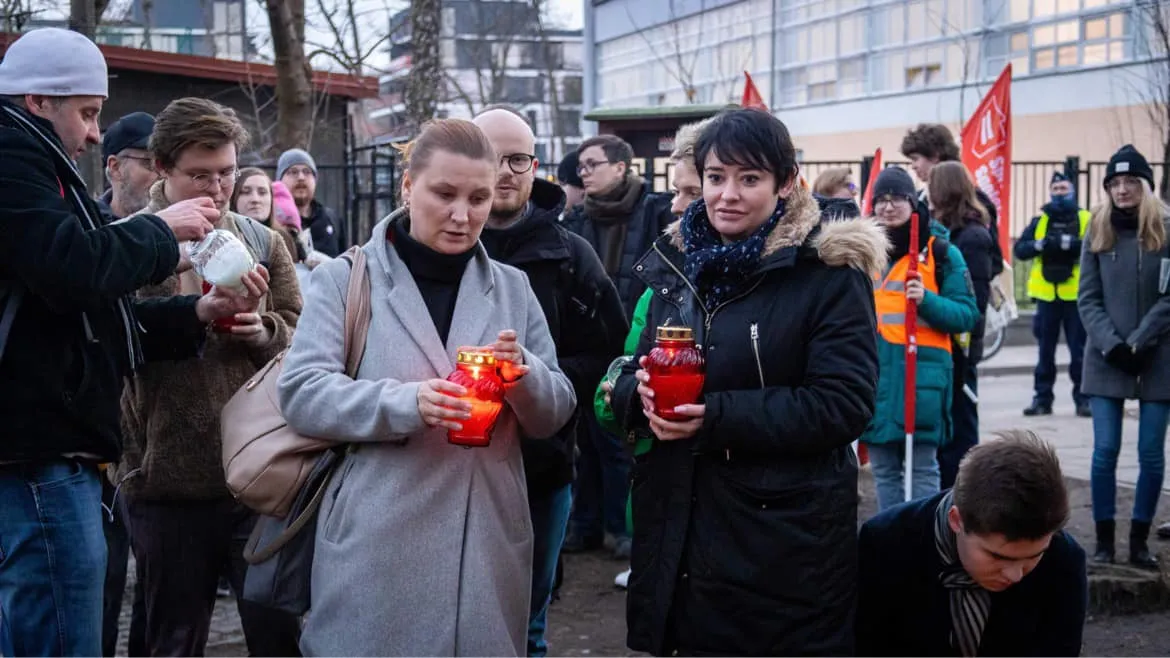 Grupa osób na zewnątrz trzyma zapalone czerwone świeczki podczas 11. rocznicy śmierci Jolanty Brzeskiej.