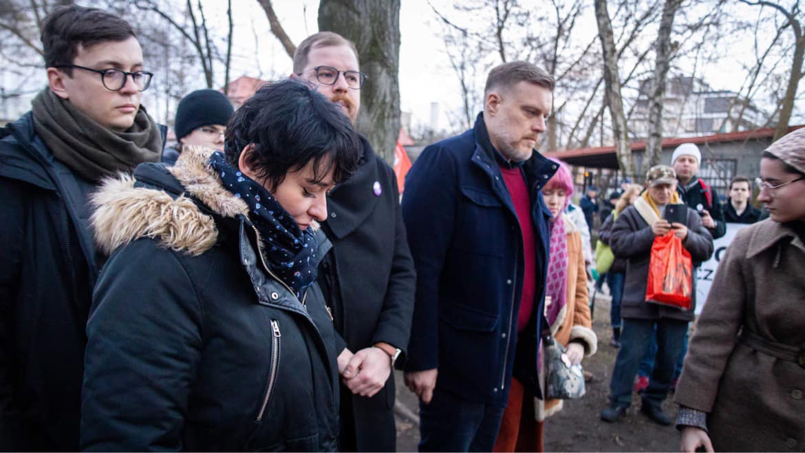 Grupa ludzi w zimowych ubraniach stoi na zewnątrz podczas 11. rocznicy śmierci Jolanty Brzeskiej.