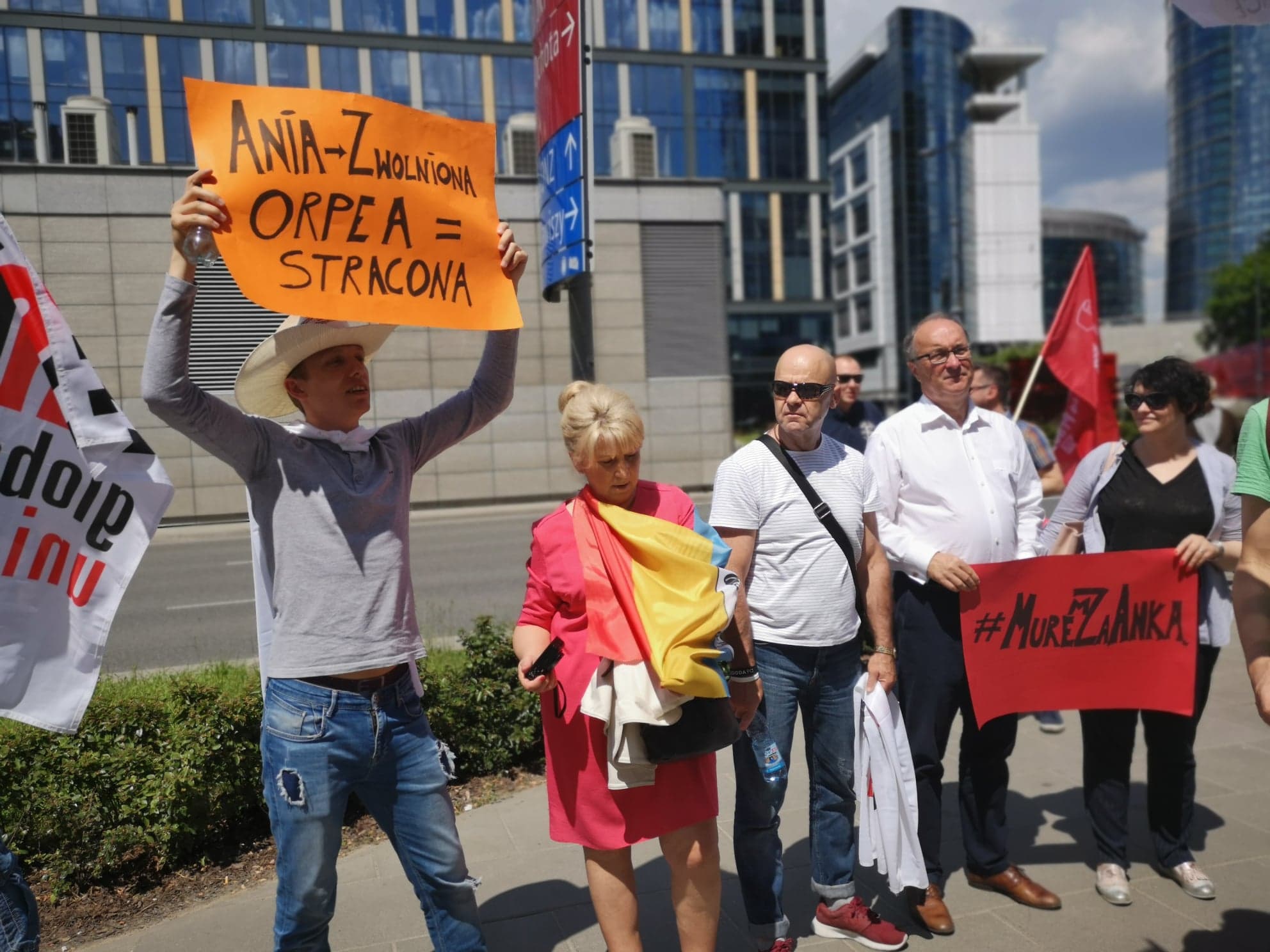 Grupa protestujących na ulicy trzyma plakaty i flagi, domagając się respektowania konstytucyjnego prawa do zrzeszania się i zakładania związków zawodowych.