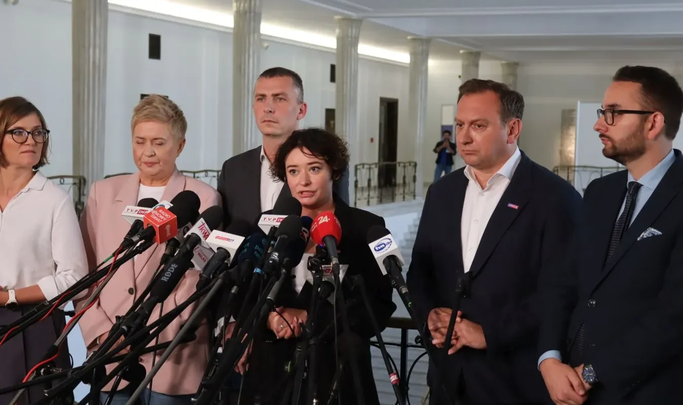 Grupa polityków i urzędników przemawia do mediów podczas konferencji prasowej o finansowaniu samorządów, mówiąc, że nowa ustawa jest potrzebna, ale musi być bardziej sprawiedliwa.