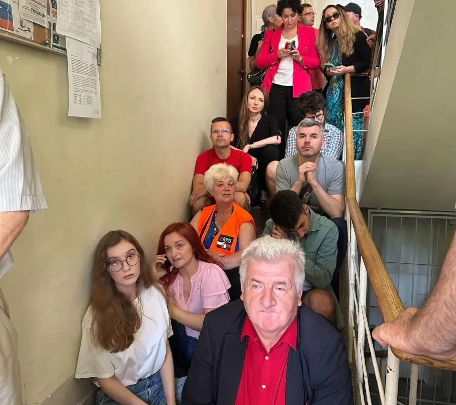Grupa osób, w tym posłowie Lewicy, zajmuje klatkę schodową podczas blokady nielegalnej eksmisji w Warszawie.