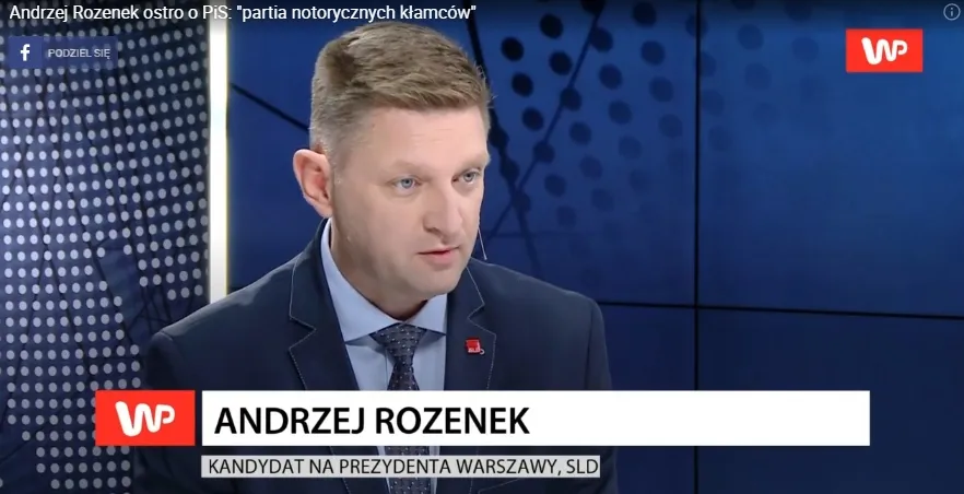 Mężczyzna w garniturze prowadzi program w studiu telewizyjnym, a na dole ekranu widnieje pasek informacyjny o kandydacie na prezydenta Warszawy oraz logo stacji WP.