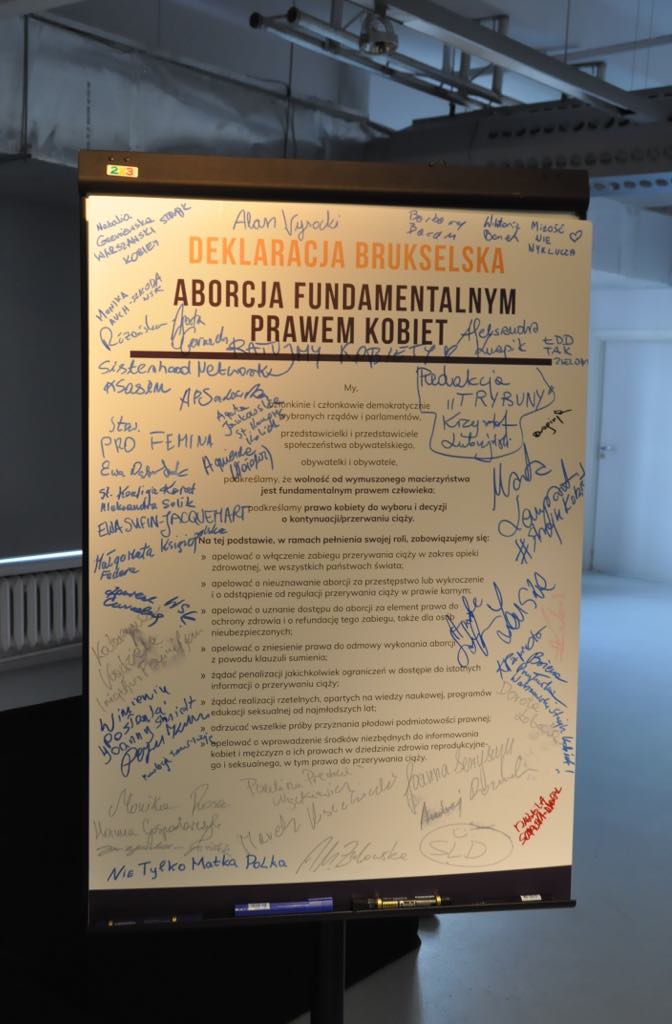 Duży plakat na stojaku z tytułem „Deklaracja Brukselska” i hasłem „Aborcja fundamentalnym prawem kobiet”, otoczony licznymi podpisami.