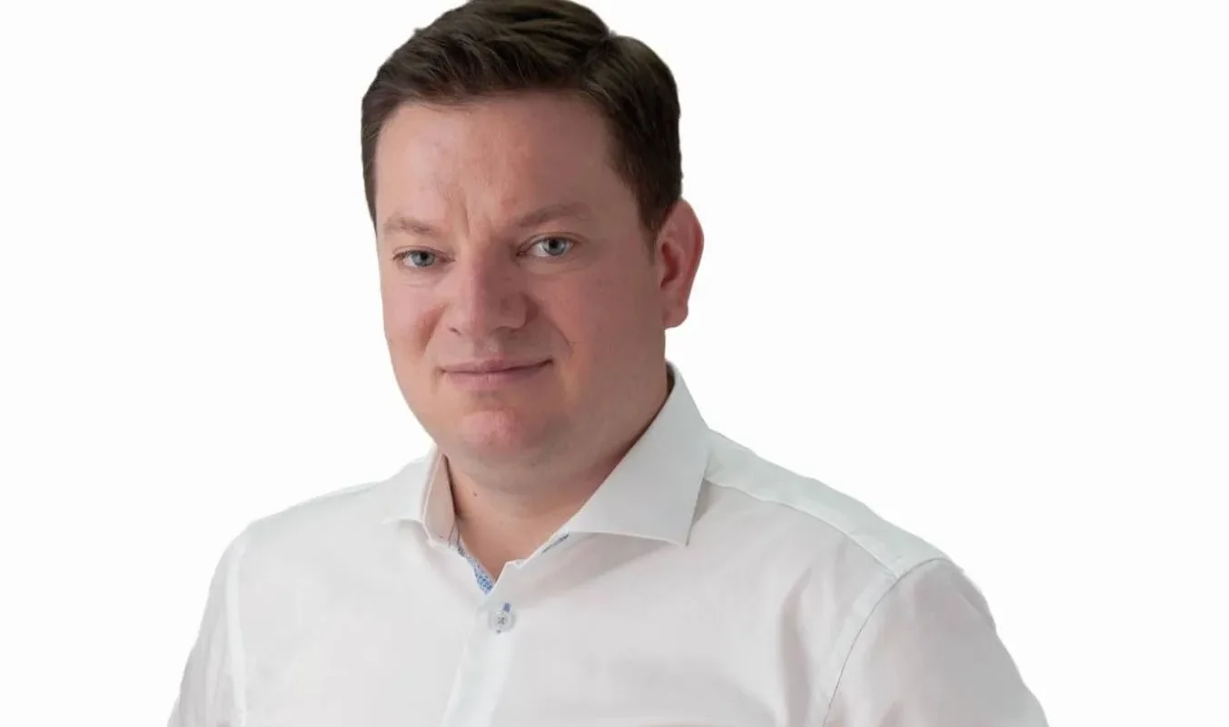 Portret mężczyzny w białej koszuli na białym tle.